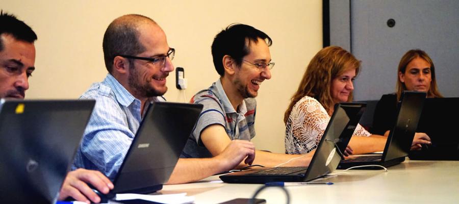 participants using computers and laughing at the 2018 opening workshop
